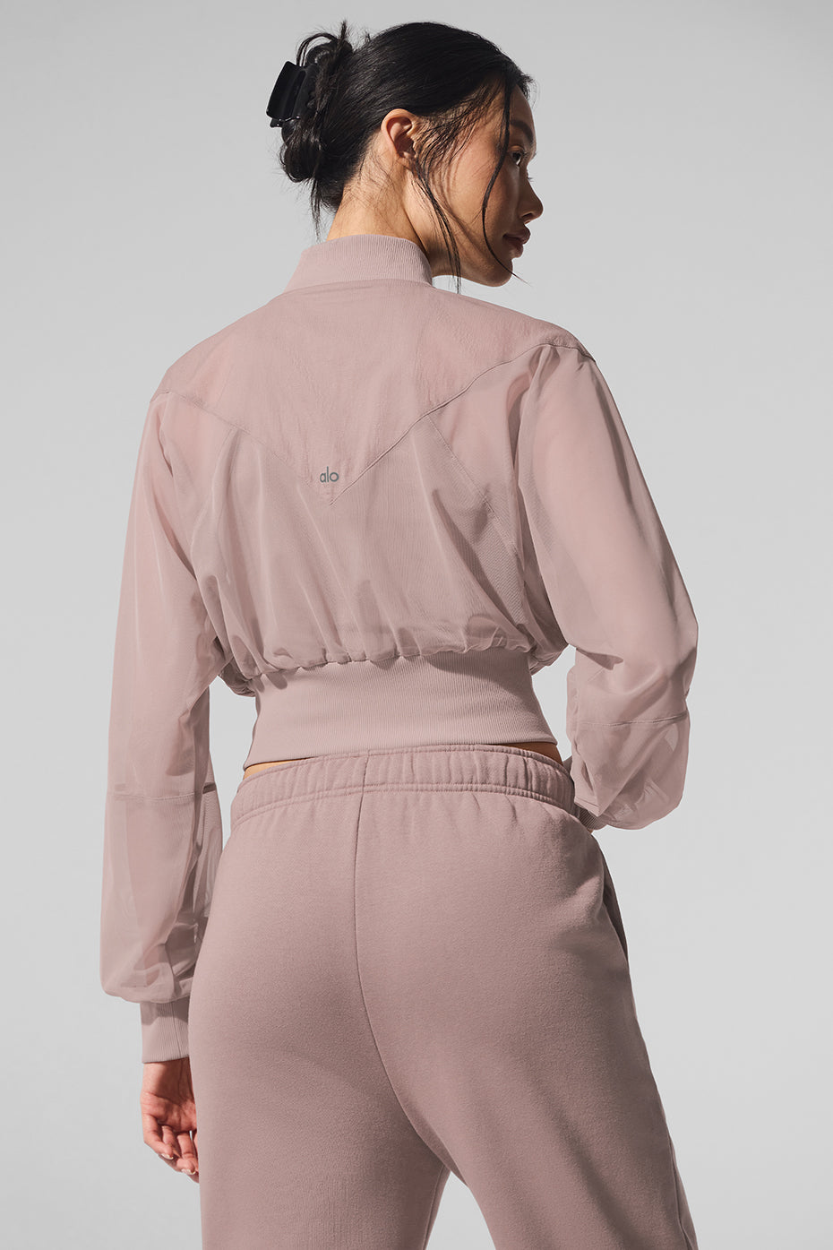 Lifestyle shot of cropped bomber jacket worn post-gym in urban setting