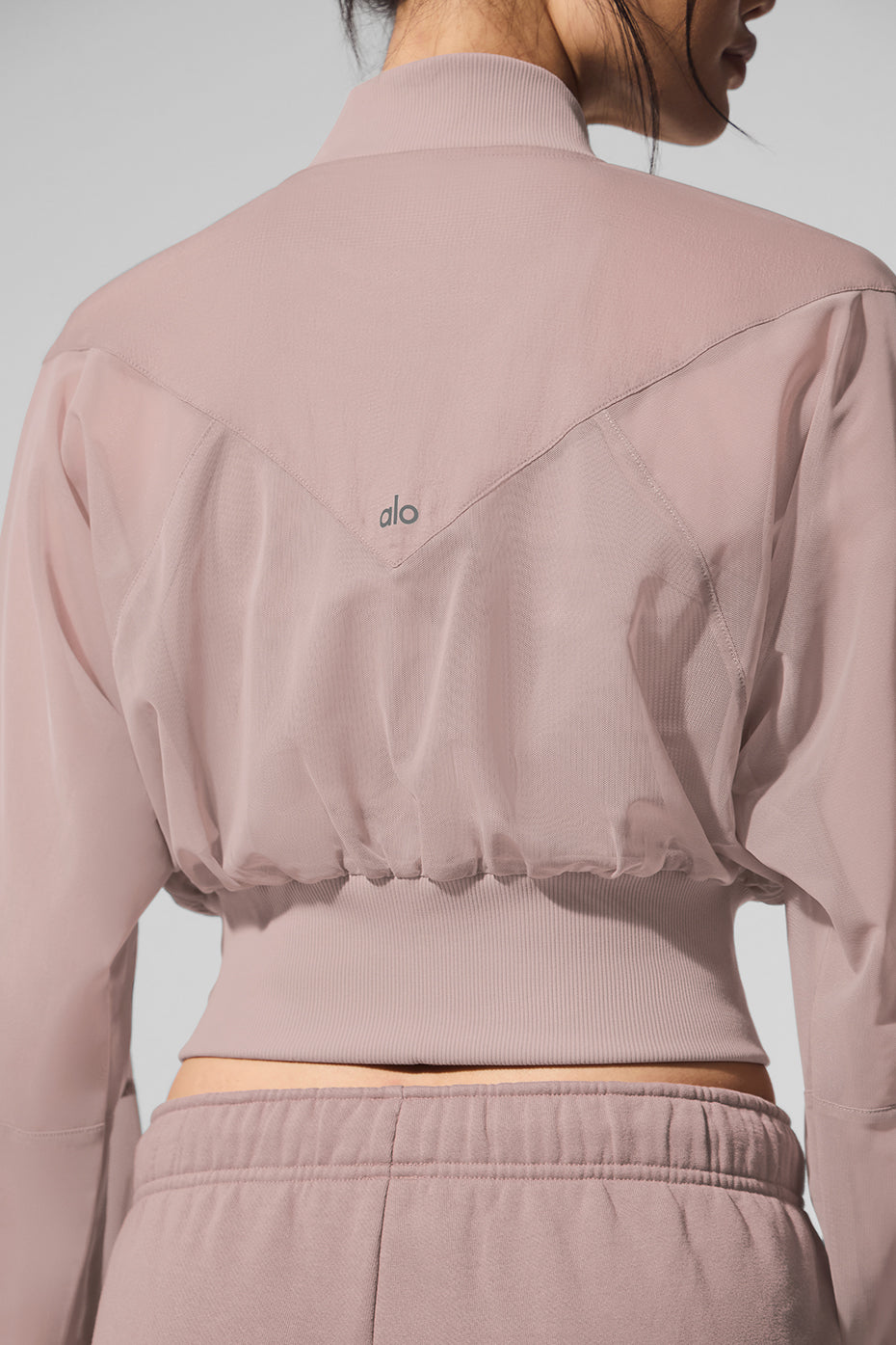 Lifestyle shot of cropped bomber jacket worn post-gym in urban setting