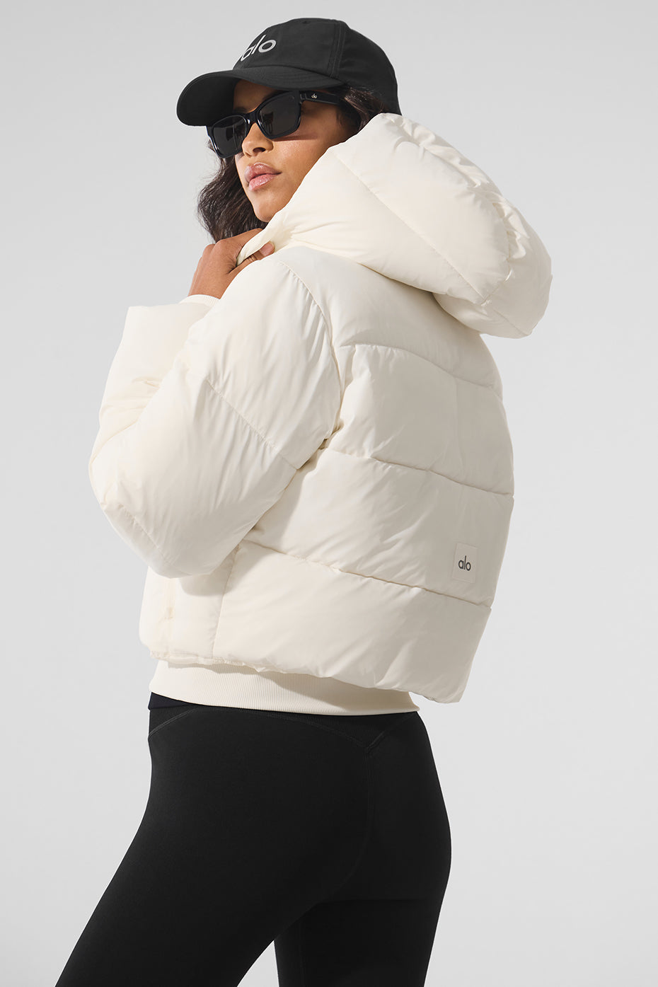 Back view of long puffer jacket womens design with city skyline