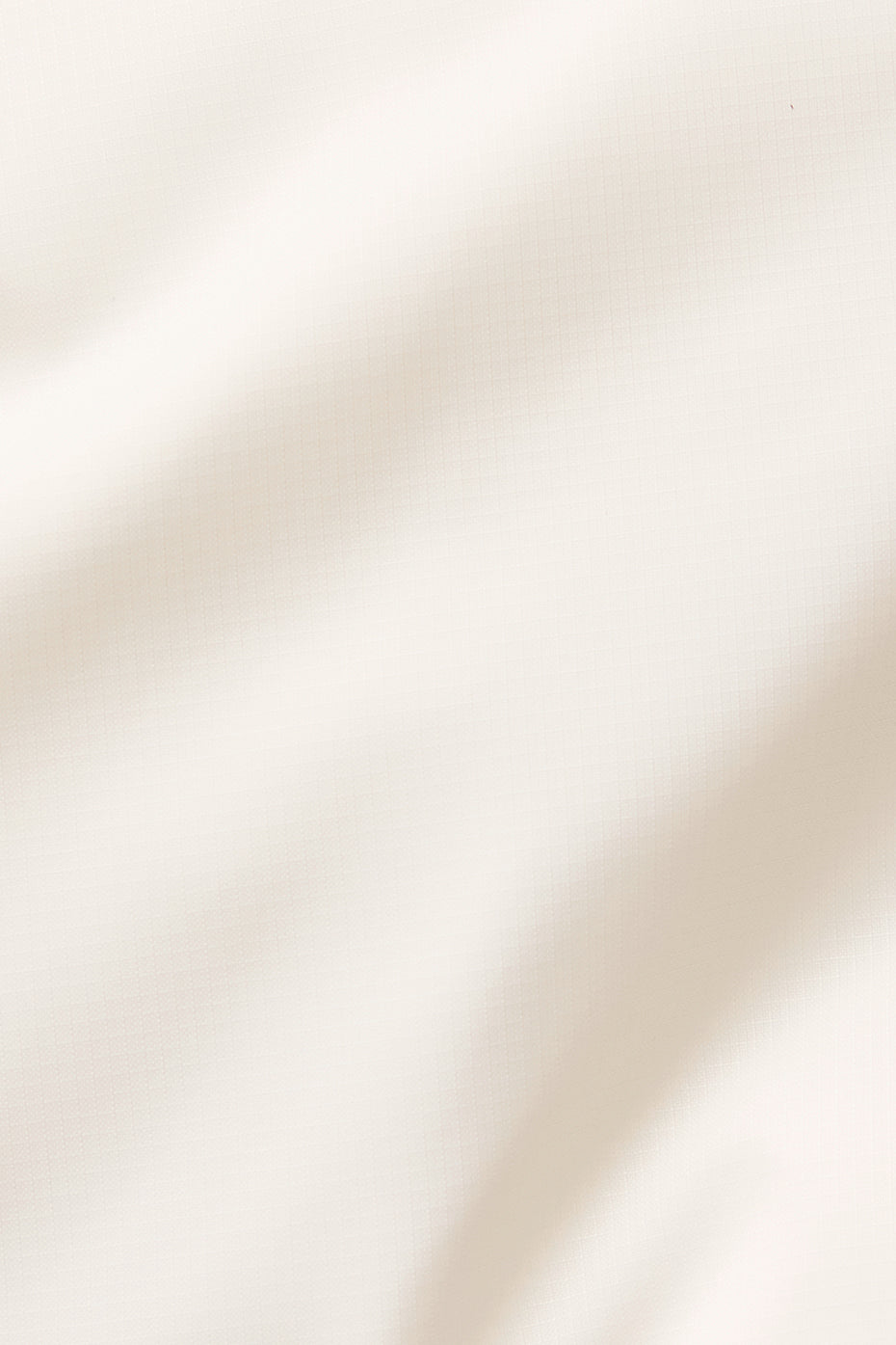Close-up of ivory puffer jacket zipper and quilted detailing