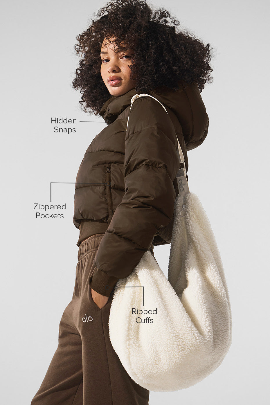 Woman walking outdoors in a city wearing a black puffer jacket, winter coat style