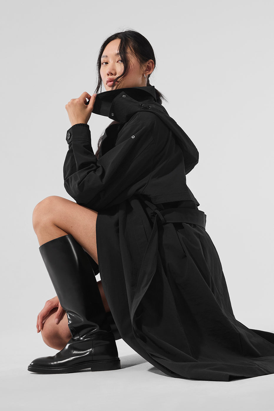 Back view highlighting the removable belt of the black trench coat