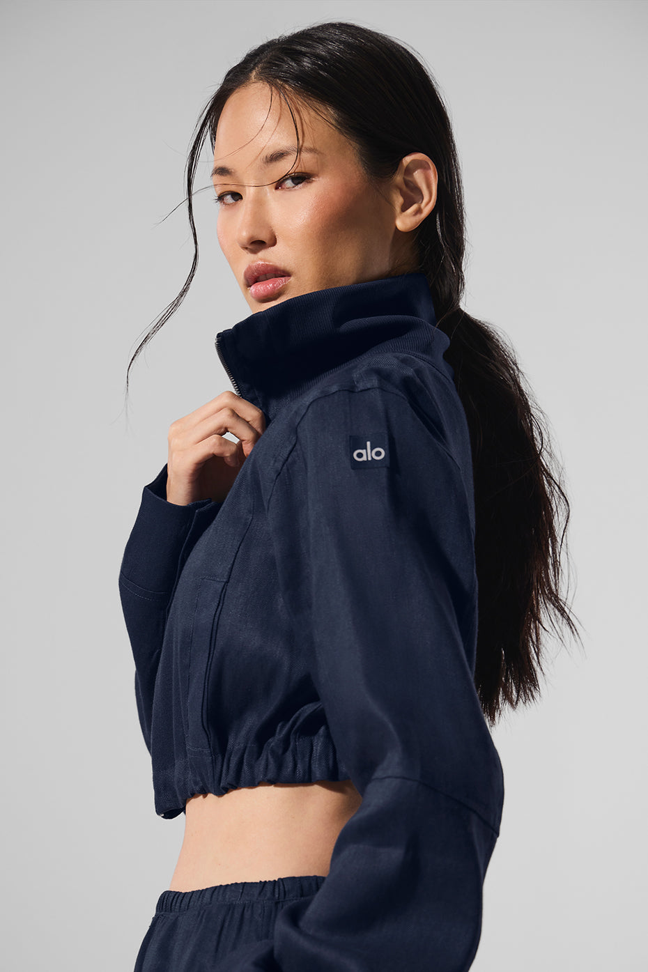 Side angle of the cropped linen jacket showcasing its unique asymmetrical hem.