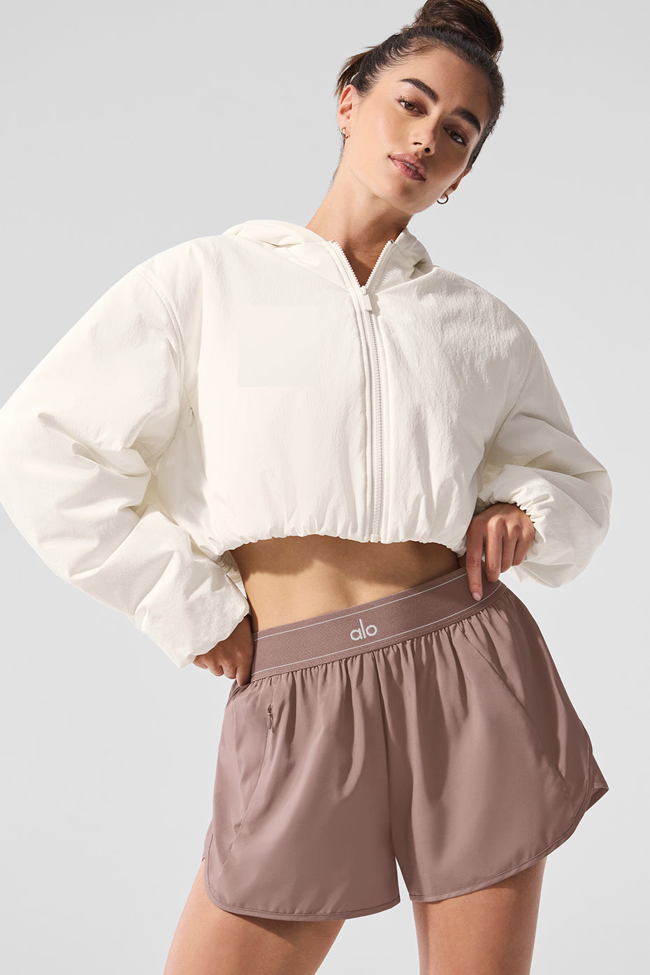 Front-facing view of ivory crop top hoodie worn casually with jeans in Brooklyn