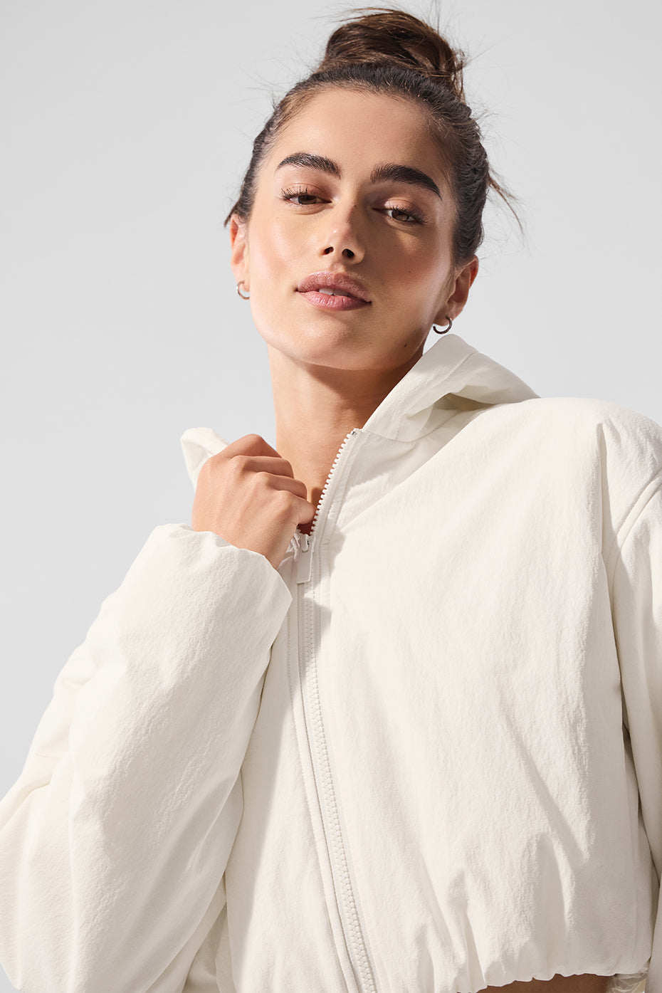 Front-facing view of ivory crop top hoodie worn casually with jeans in Brooklyn