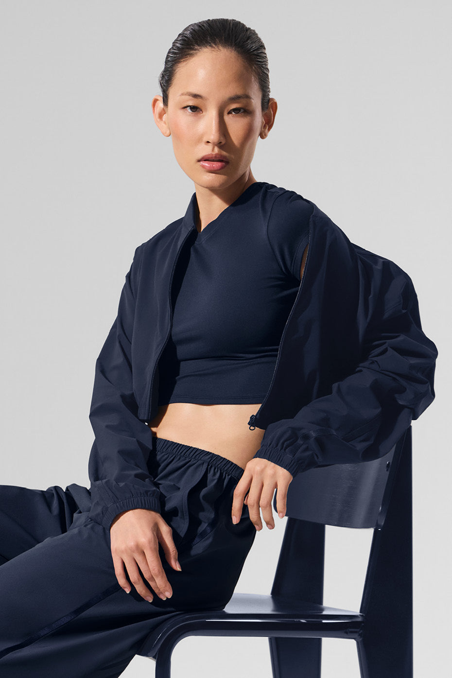 Back view of cropped puffer jacket styled with high-waisted trousers