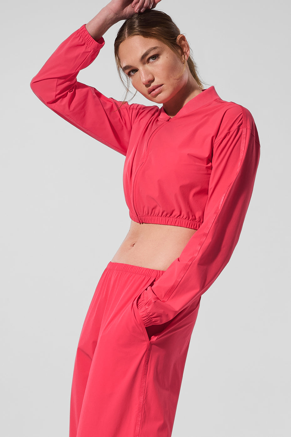 Front view of candy red cropped jacket styled with jeans