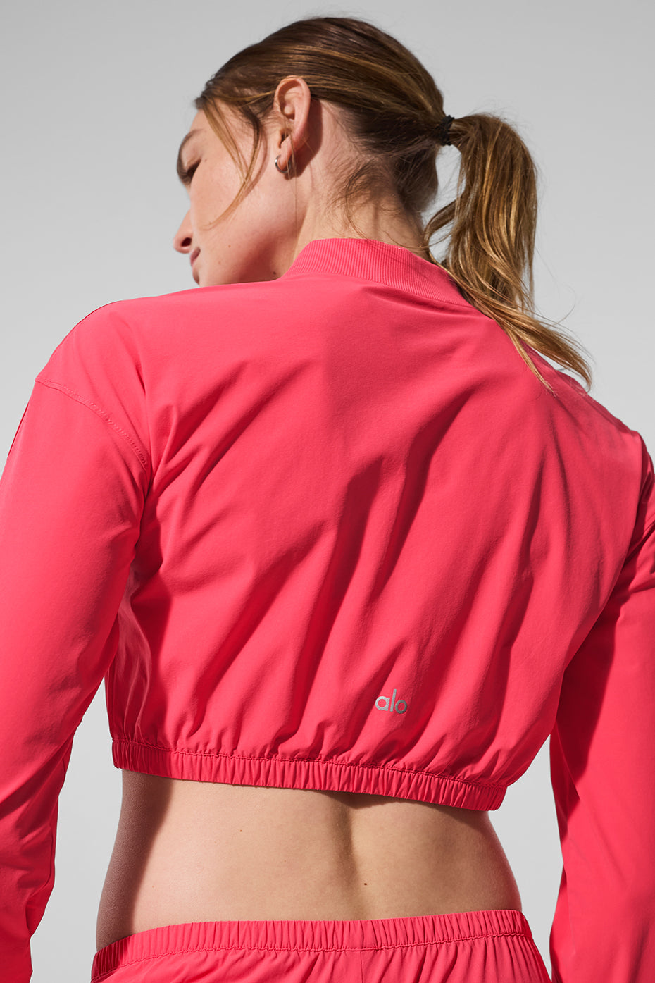Front view of candy red cropped jacket styled with jeans