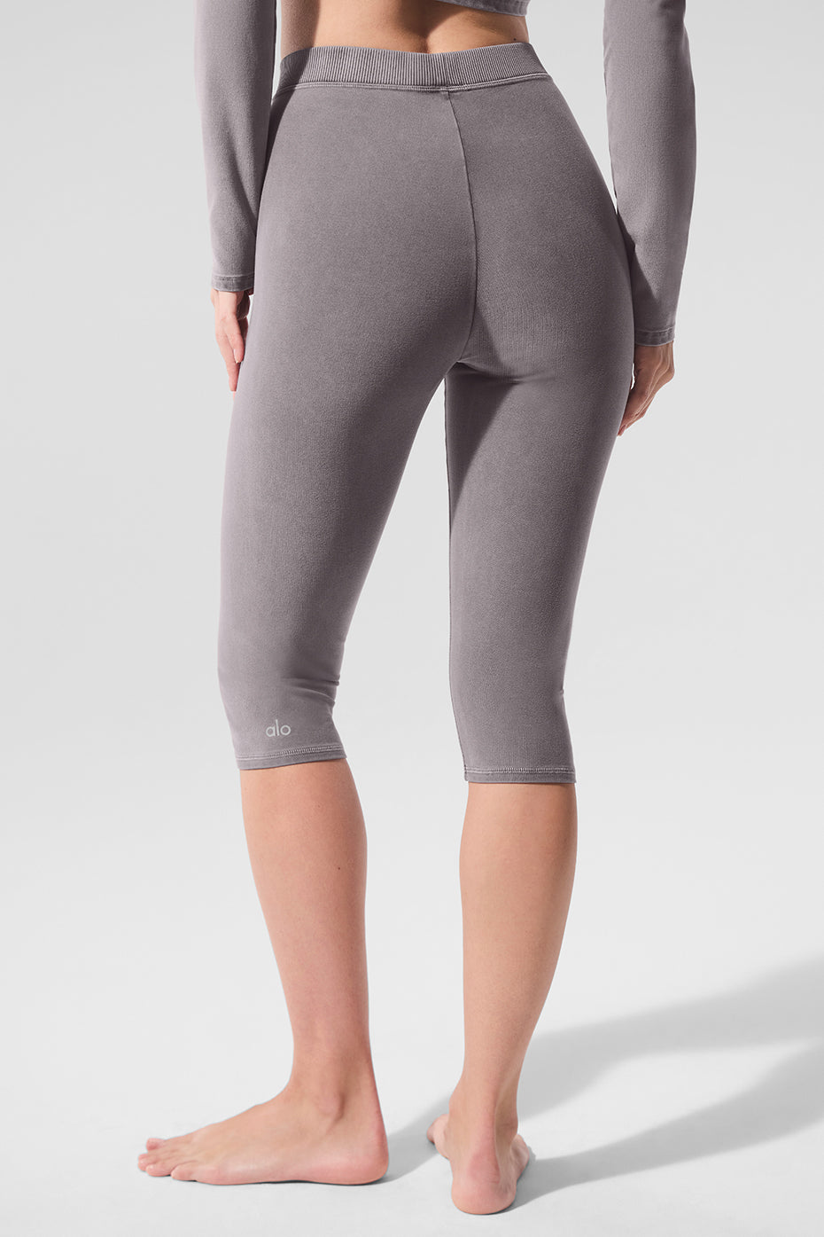 Back view showcasing the fit of high-waist capri pants in cool grey.