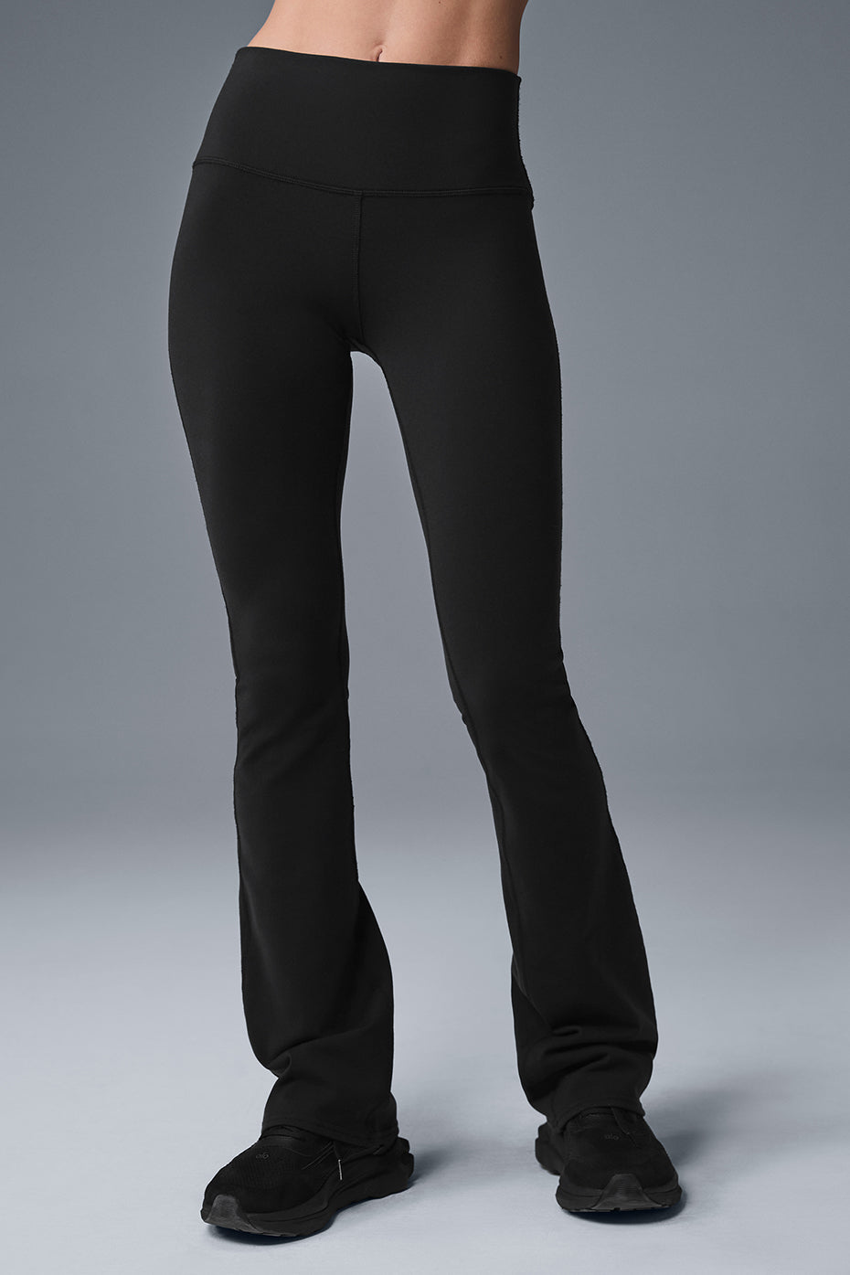 Model wearing black bootcut leggings with high waistband, side profile view