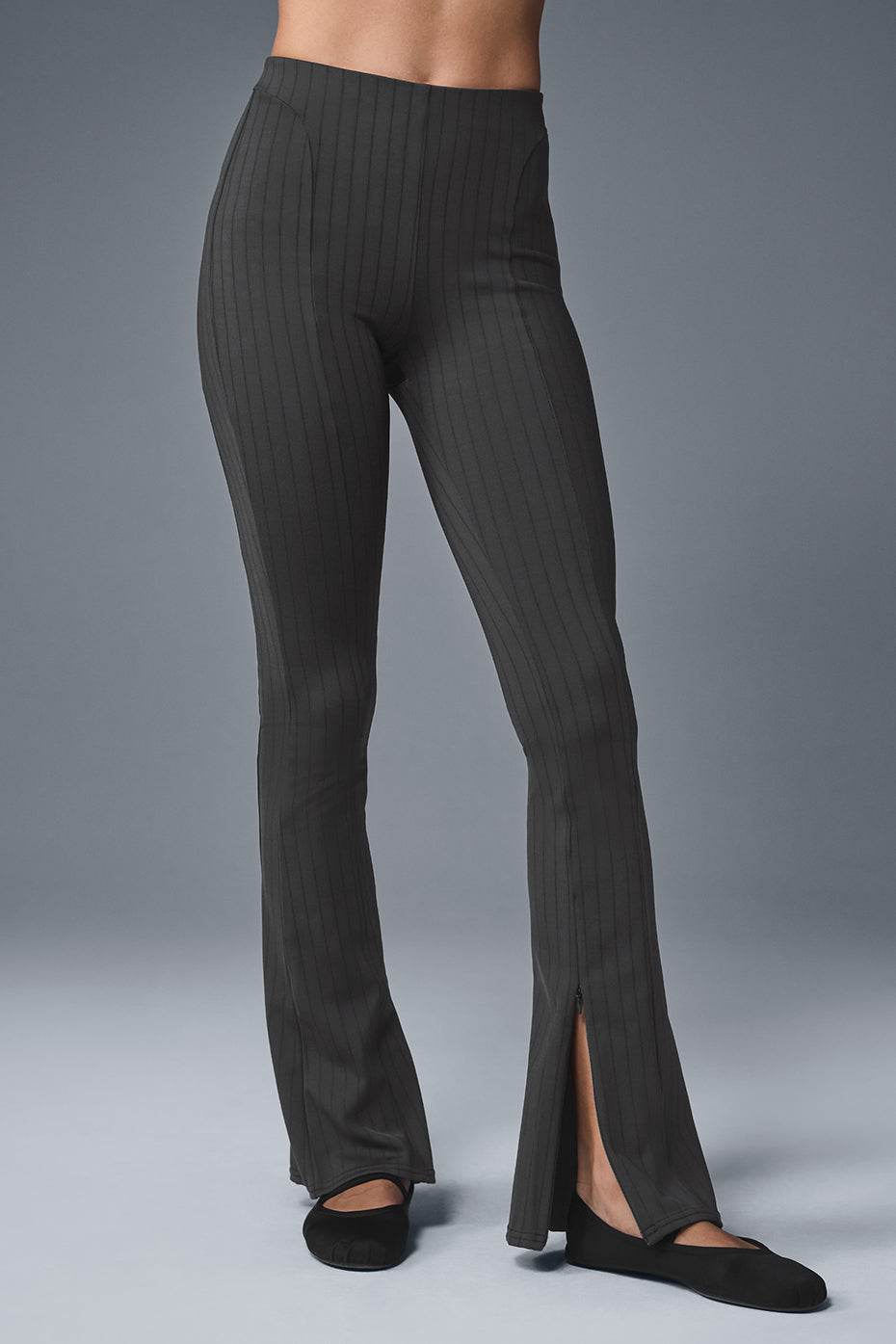Side view of flared leggings with zip open showing ankle sneakers