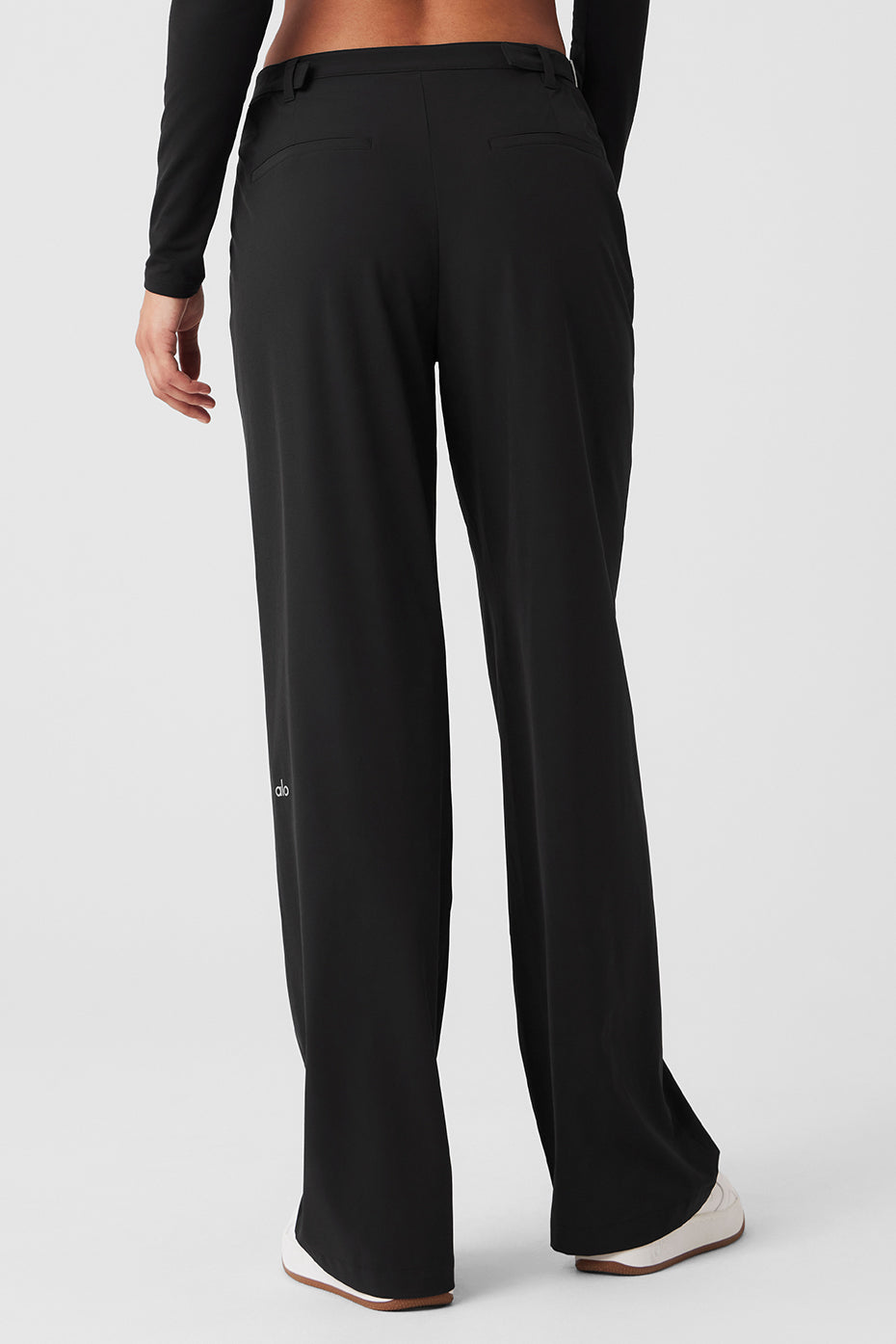 Front view of stylish black mid-rise trousers with cut outs and side buckles.