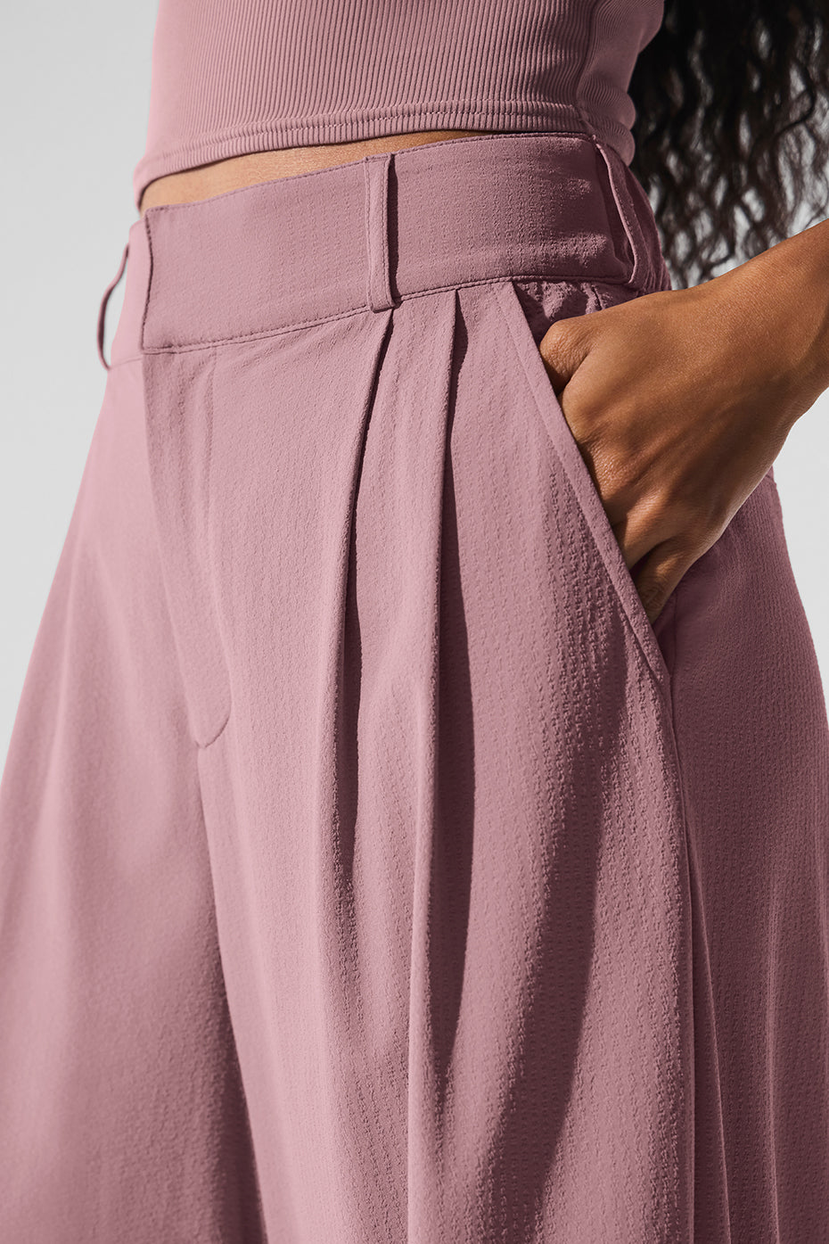 Front view of high-waisted trousers on female model in urban setting