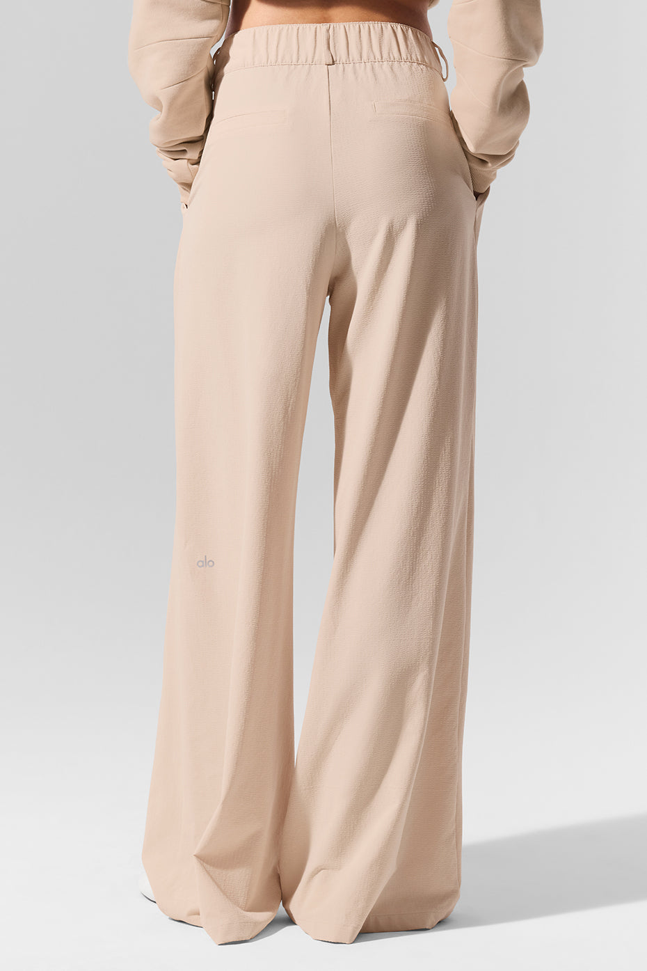 Close-up of lightweight crinkle woven fabric on pleated trousers, breathable and stylish