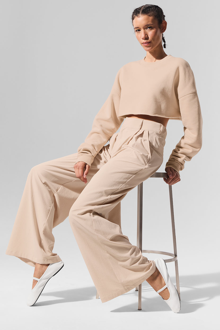 Model pairing pleated trousers pants with a chic blouse for a trendy look