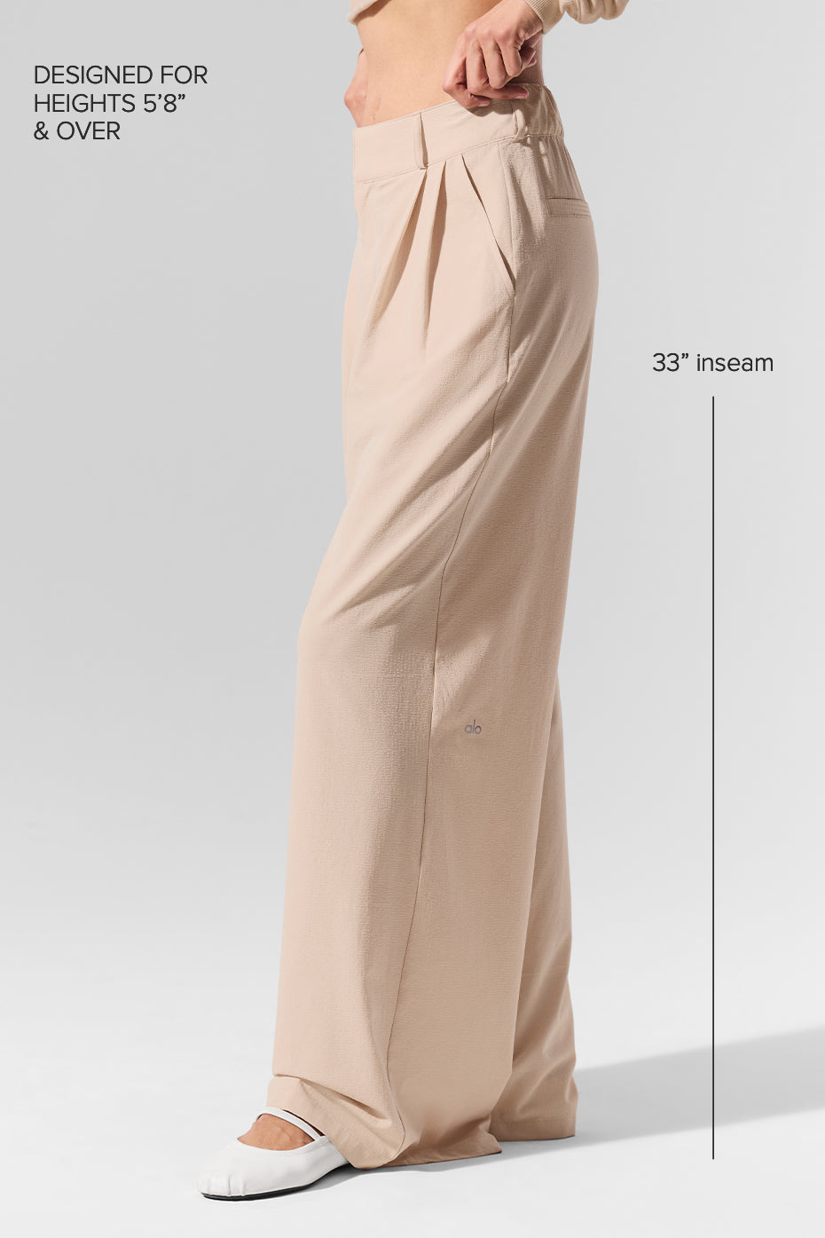 Model pairing pleated trousers pants with a chic blouse for a trendy look
