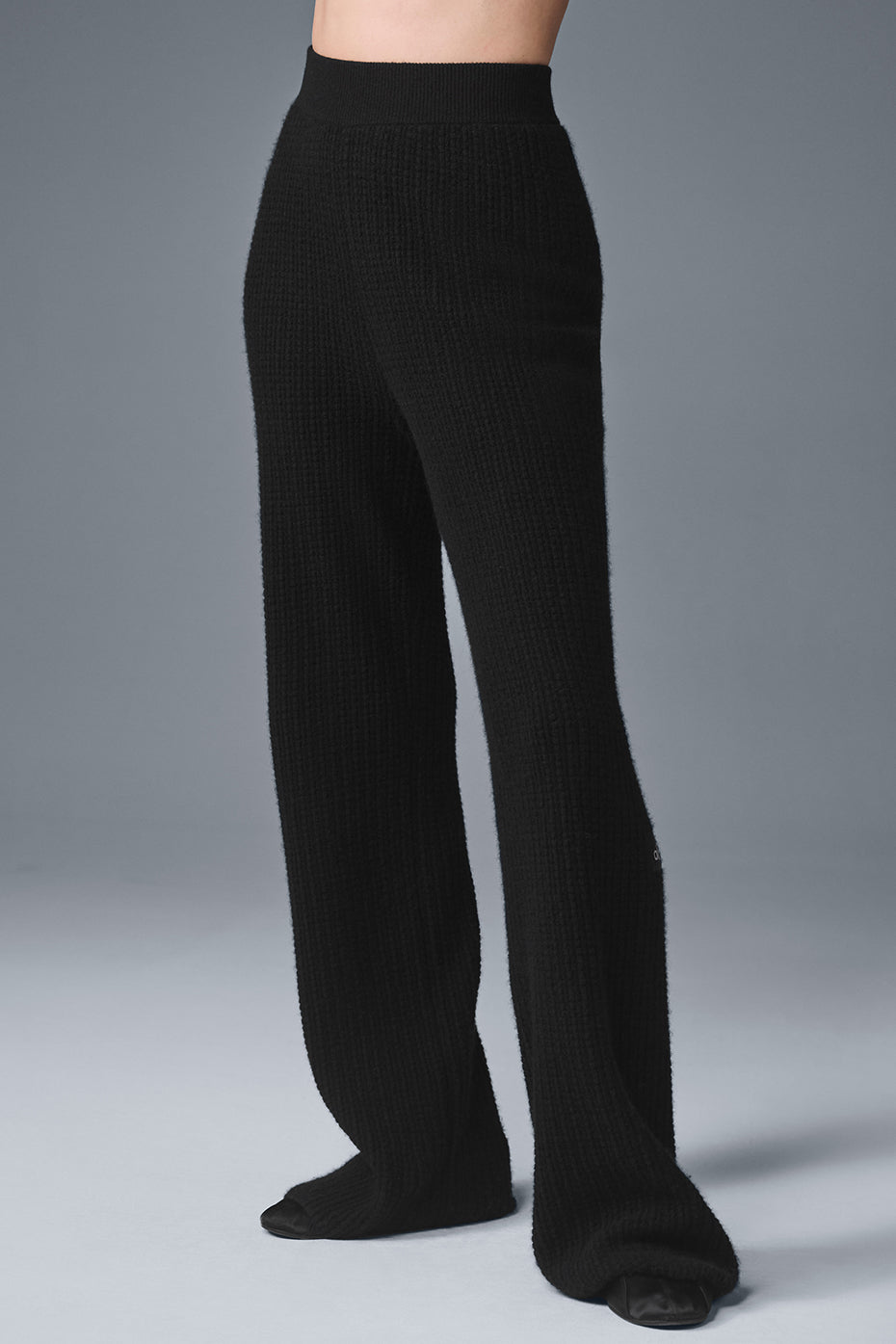 Front view of luxurious cashmere high-waisted pants in black, showcasing the waffle texture.