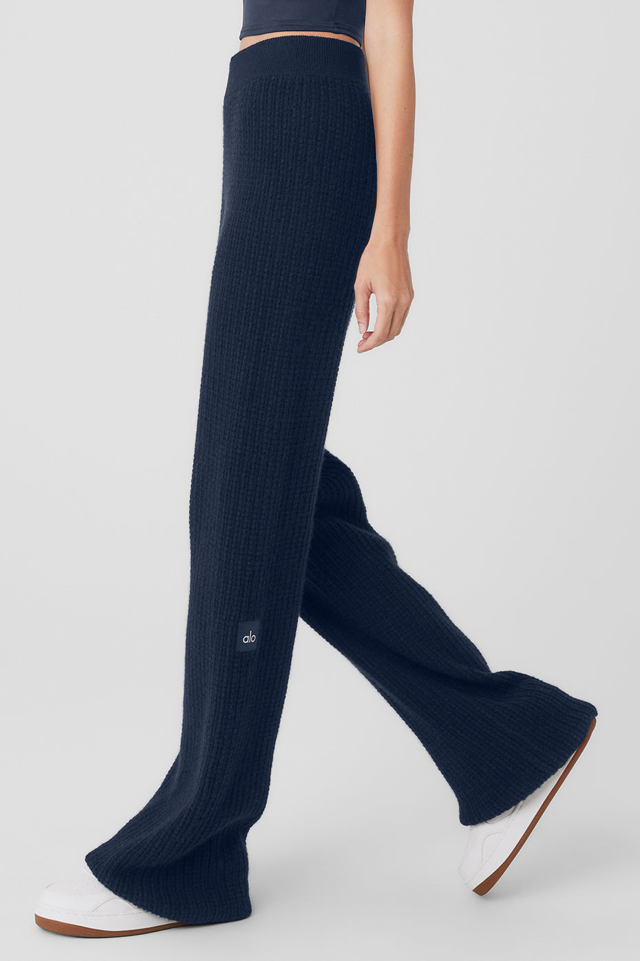 Close-up of plush cashmere fabric in high-waist pants, showcasing texture.
