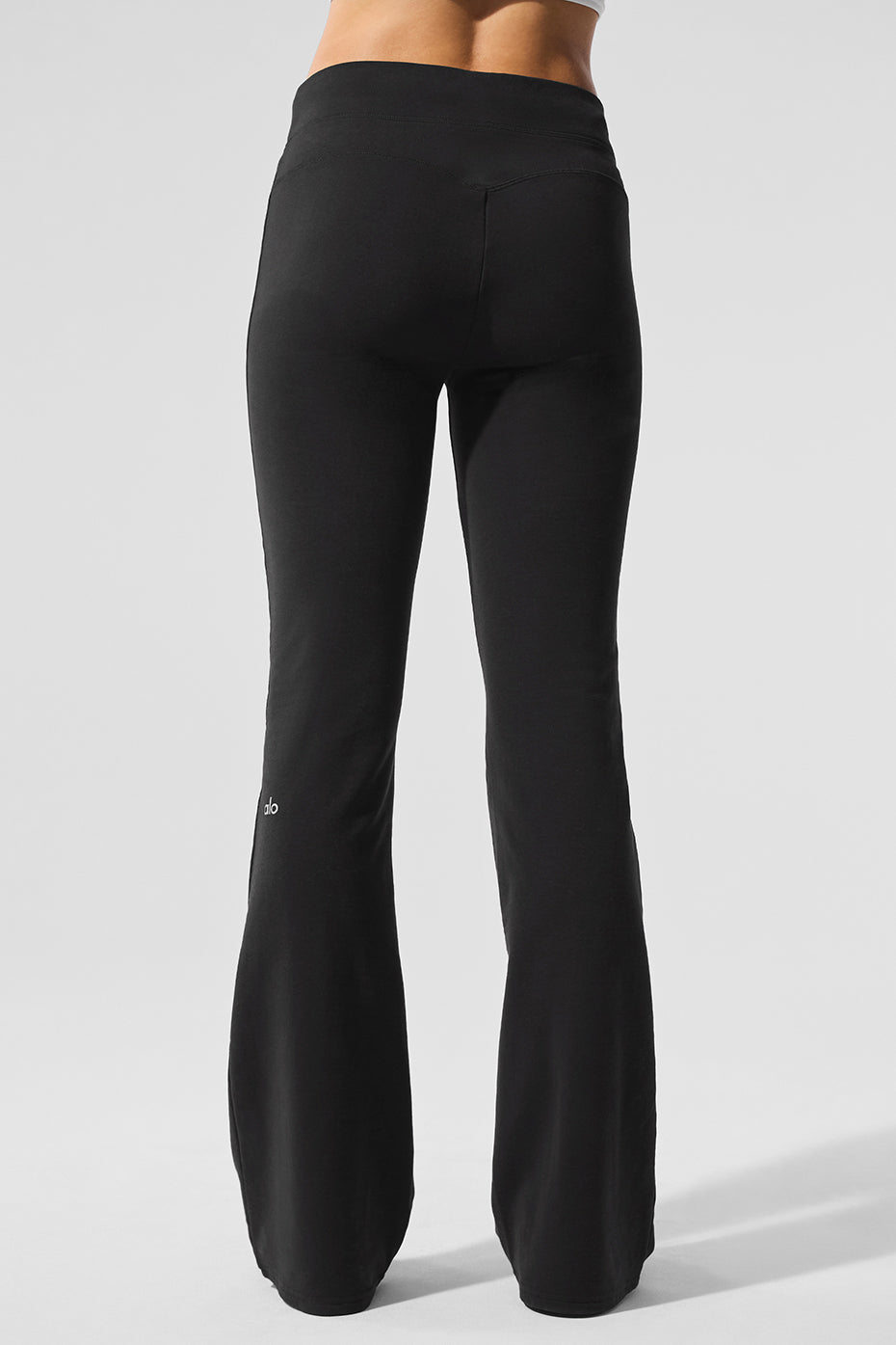 Model wearing black bootcut sweatpants in a relaxed, casual setting