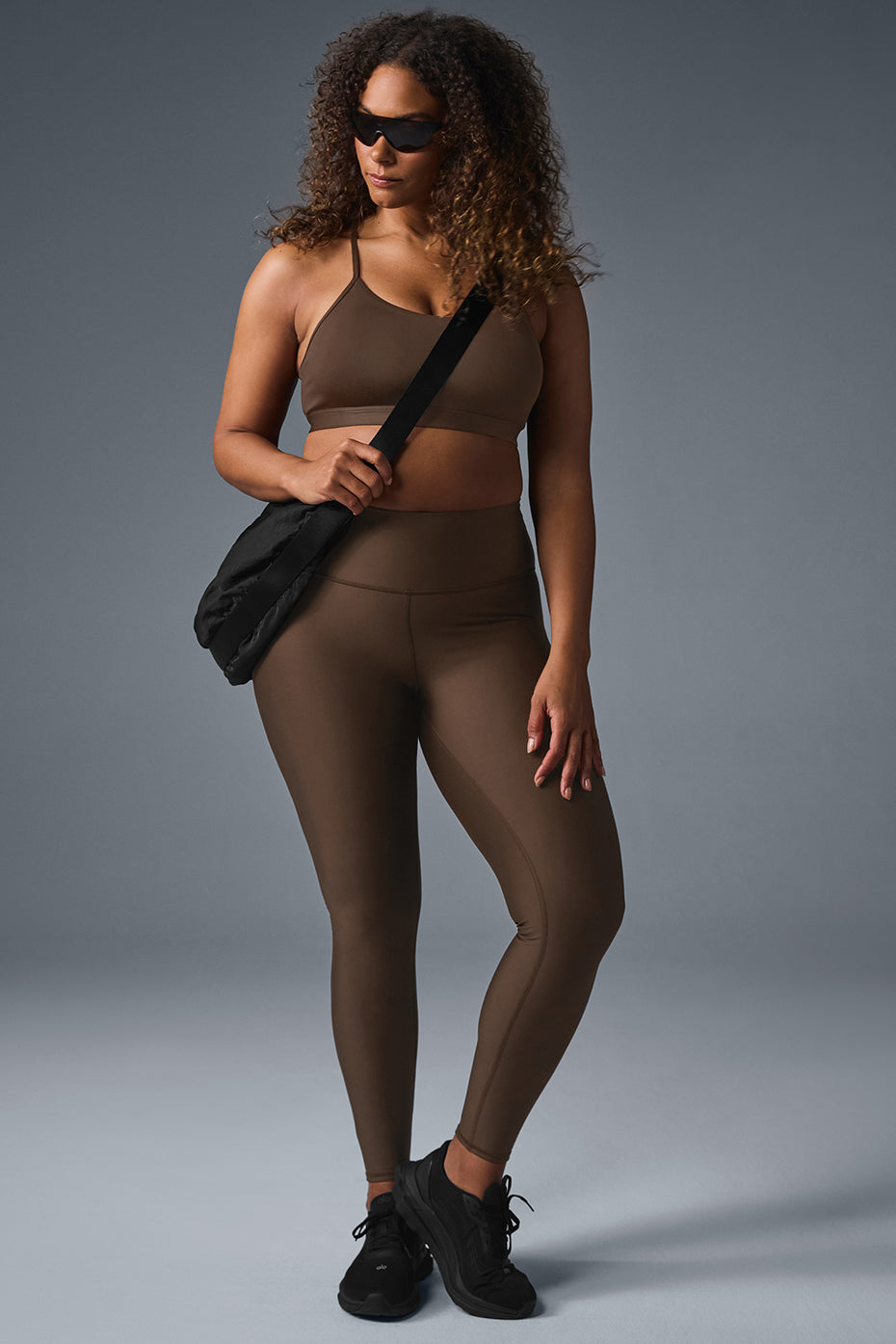 Model wearing espresso high-waist leggings during a workout outdoors