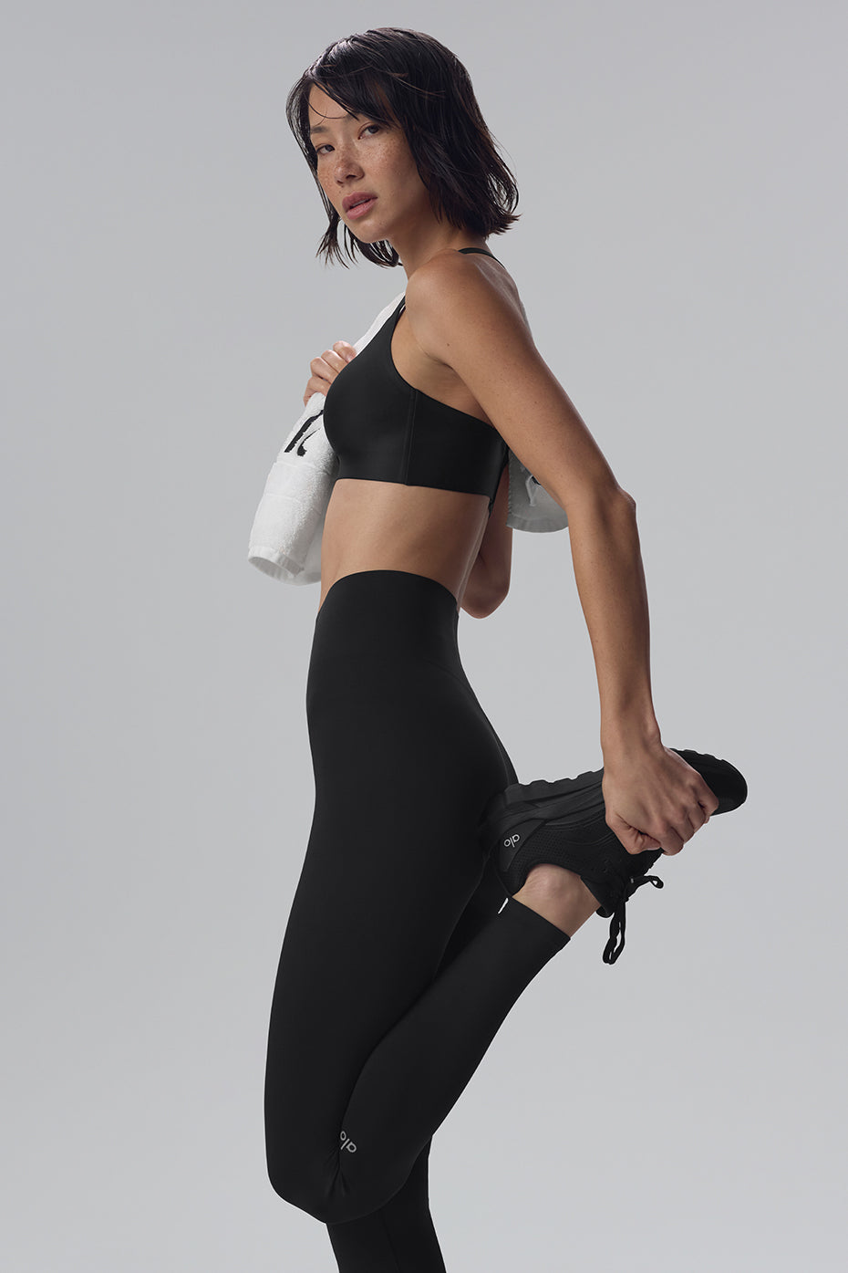 High-waisted black workout leggings on model, side view