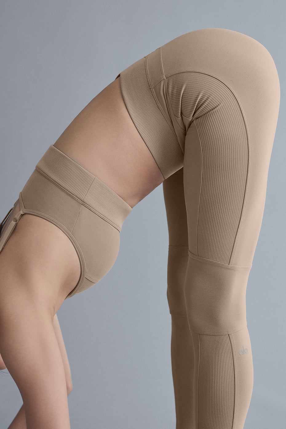 Model wearing full-length leggings with contrasting ribbed panels and matching sports bra