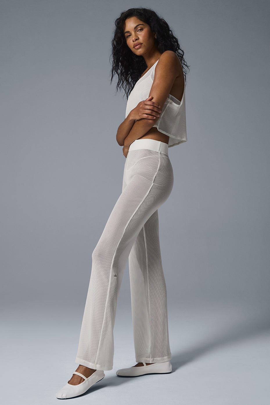 Front view of ivory striped mesh flare pants on a model.