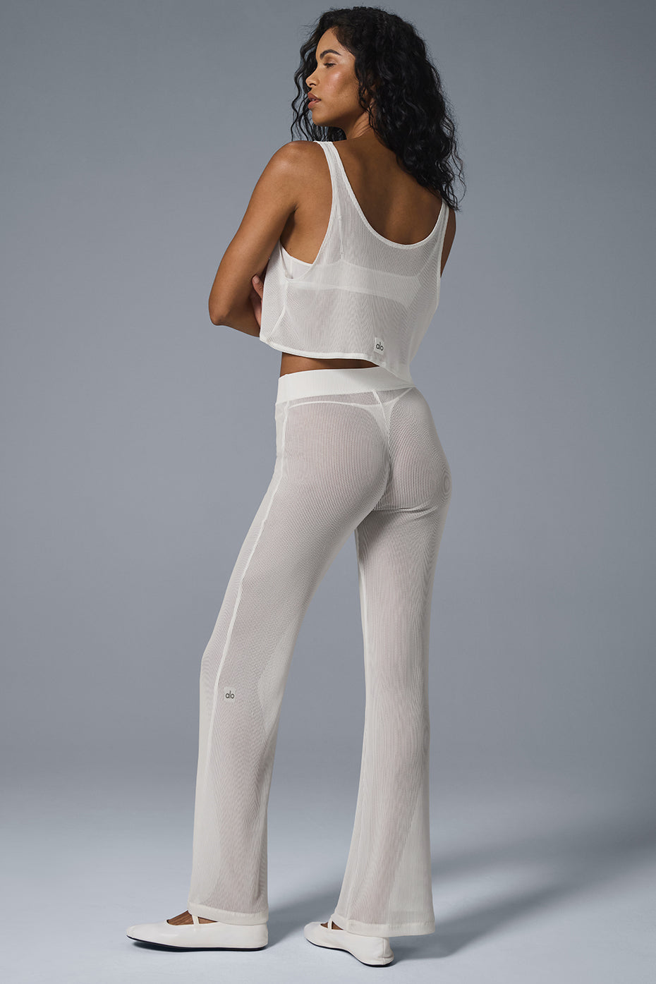 Front view of ivory striped mesh flare pants on a model.