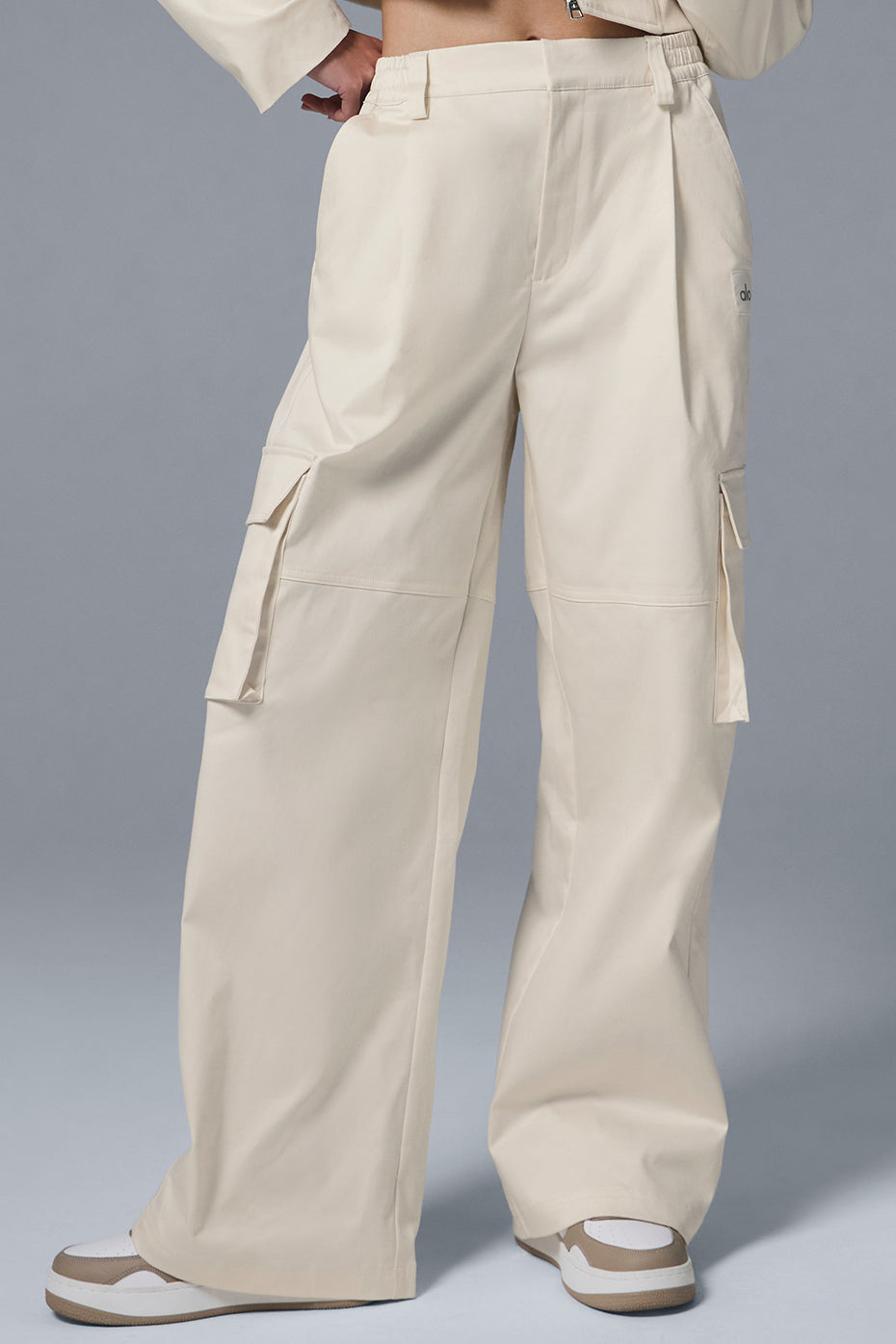 Front view of ivory high-waisted cargo trousers with pleats