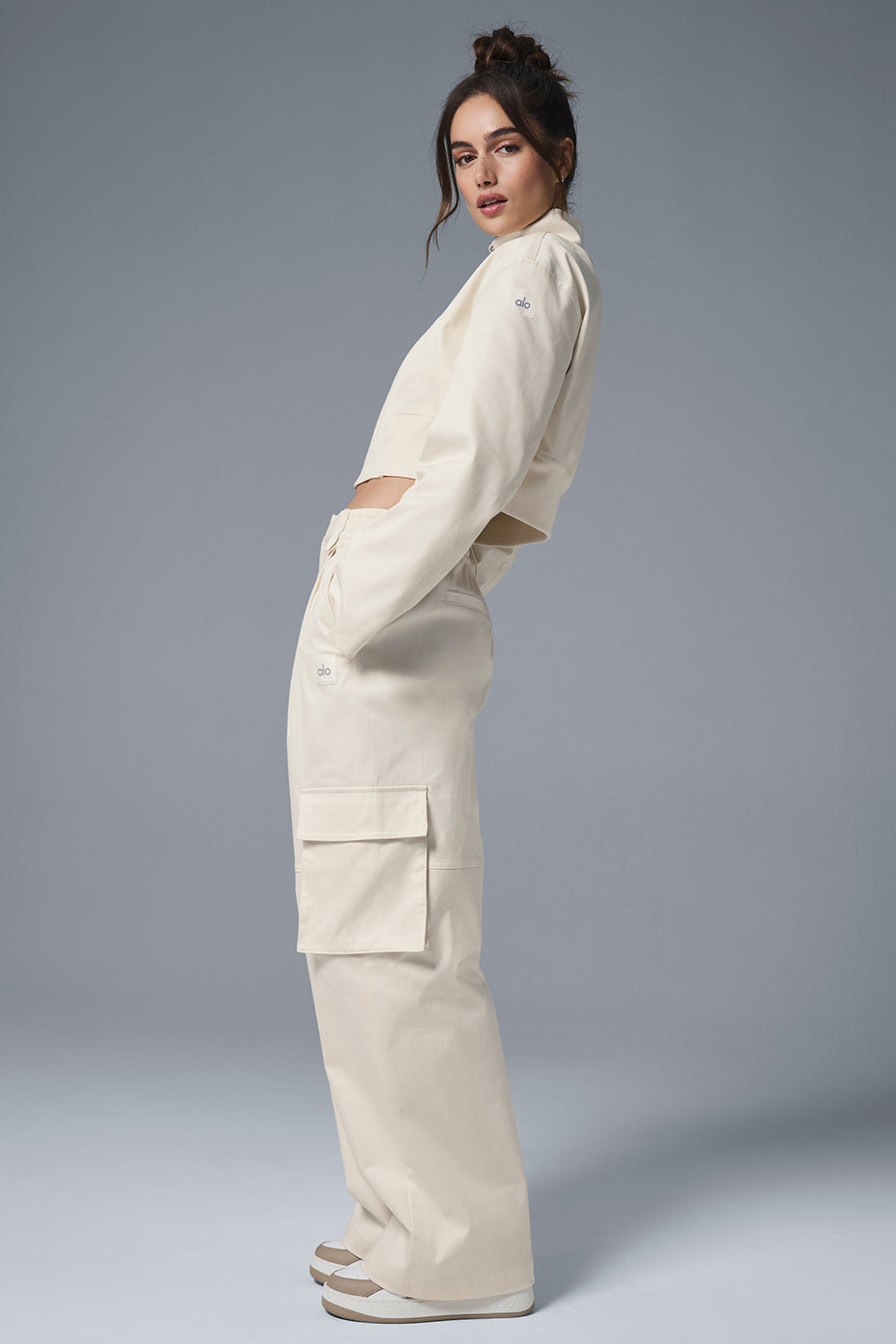 Front view of ivory high-waisted cargo trousers with pleats