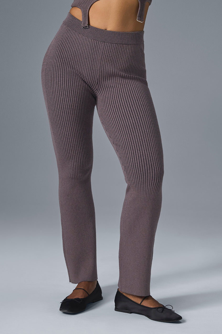 Side view of high waist flare pants worn with heels in urban setting.