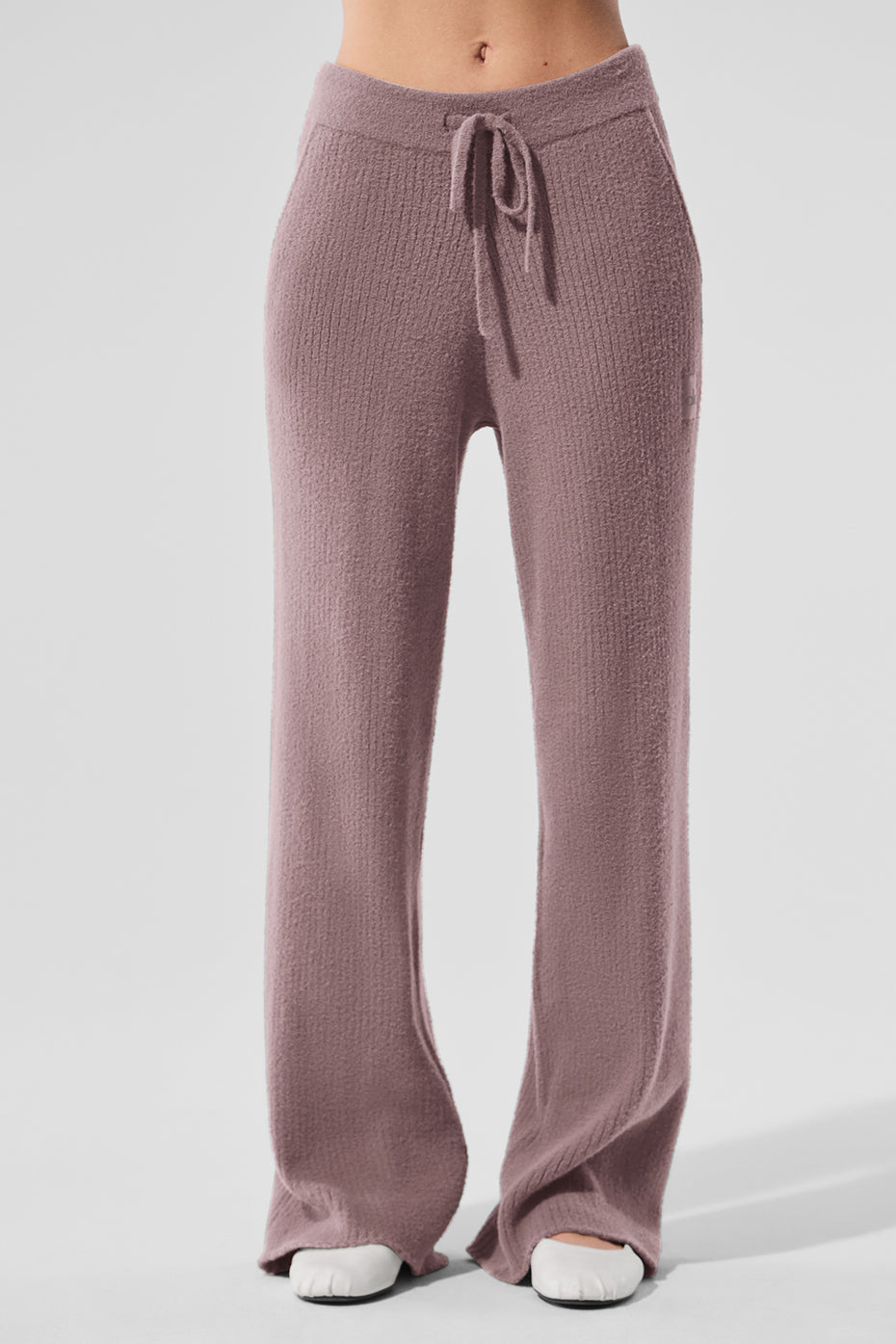 Mushroom-colored wide leg pants laid flat on a bed