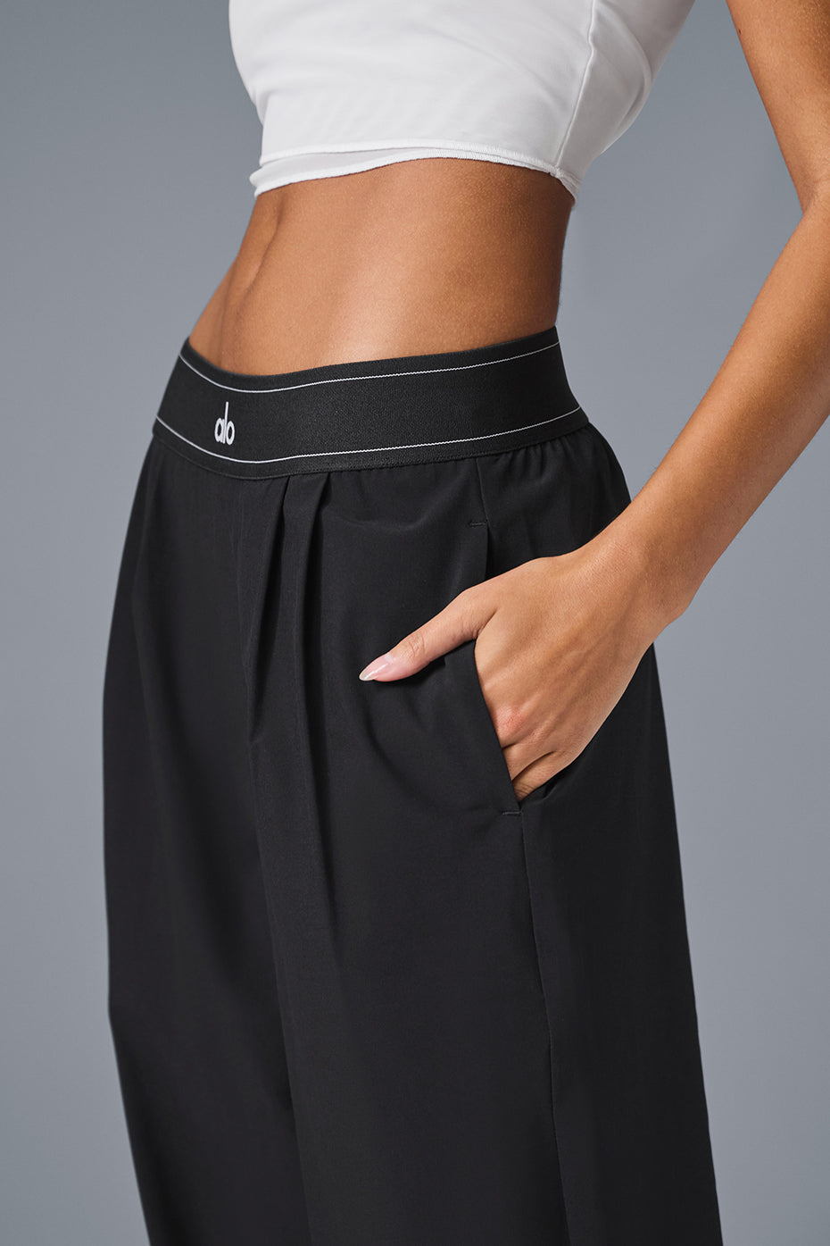 Close-up of the elastic waistband on black dress trousers for women.