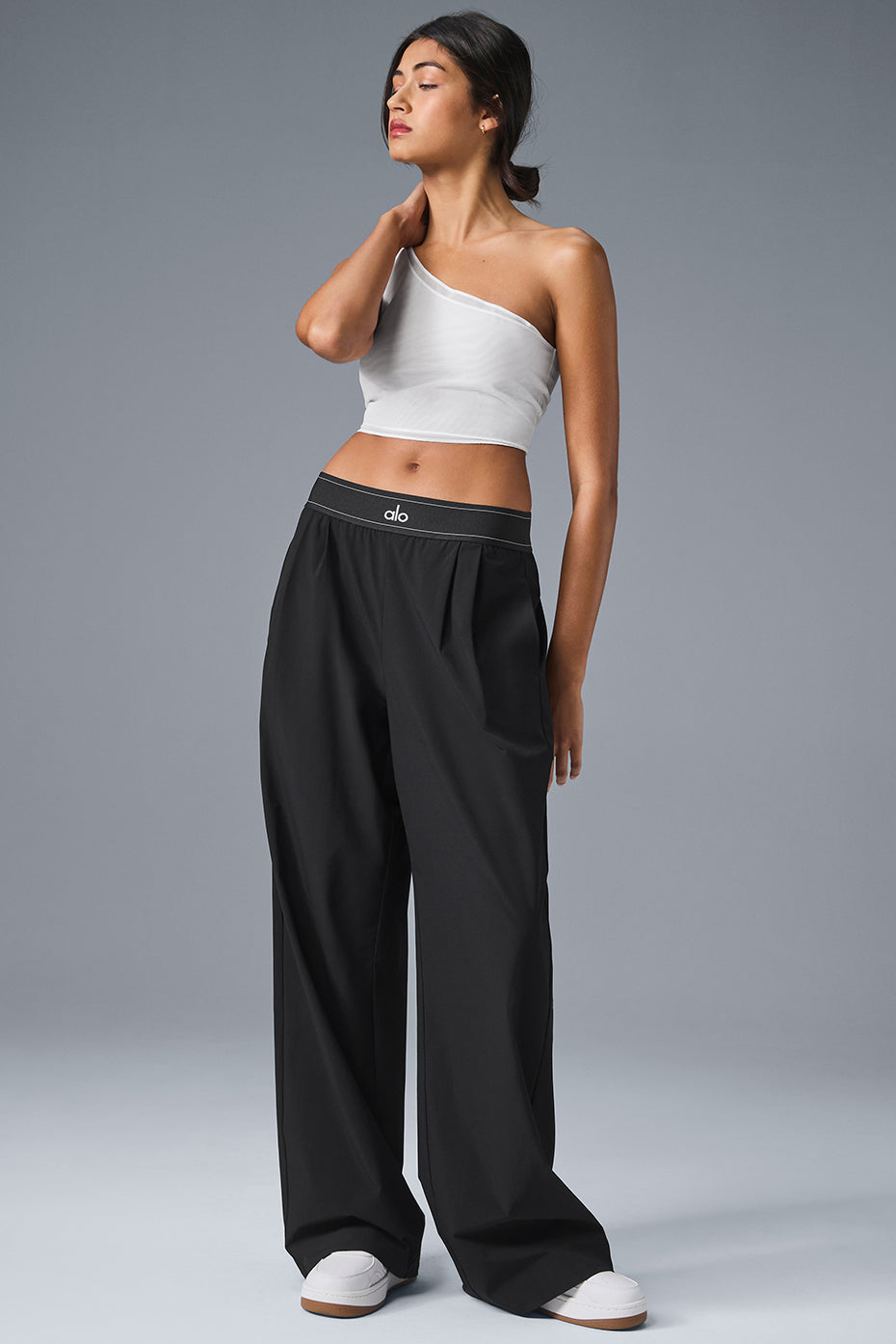 A model showcasing slim fit high-waisted pants in a stylish outfit.