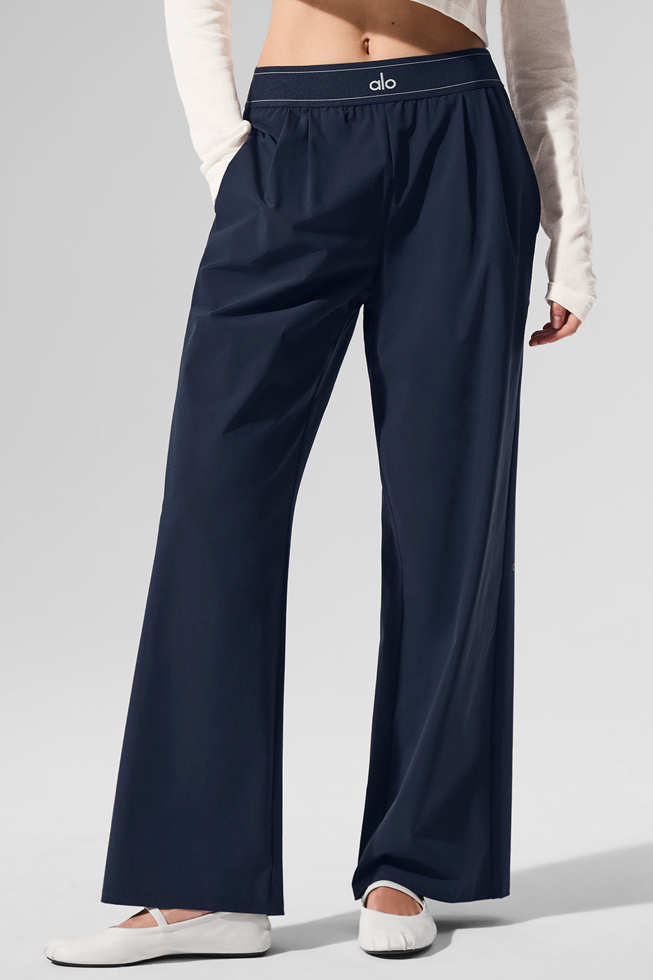 Model wearing navy trousers with a stylish top for a trendy work outfit.