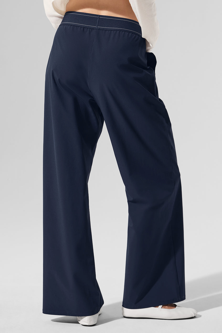 Side view of chic navy trousers showcasing the elastic waistband and straight-leg fit.