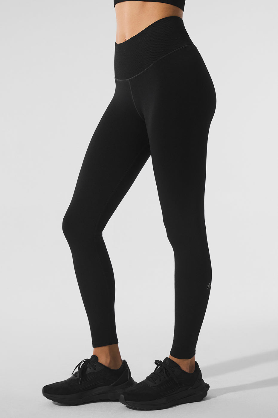 Side view of high-waist leggings styled with boots on snowy Minneapolis sidewalk