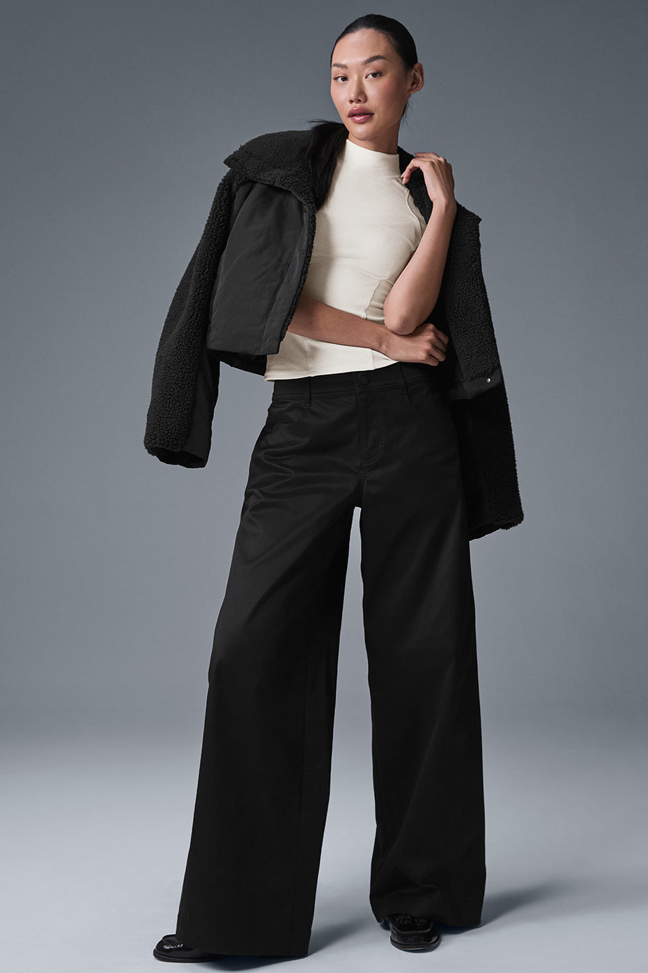 Side view showcasing the low-rise fit of black trousers.