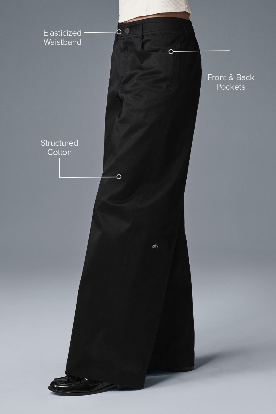 Side view showcasing the low-rise fit of black trousers.