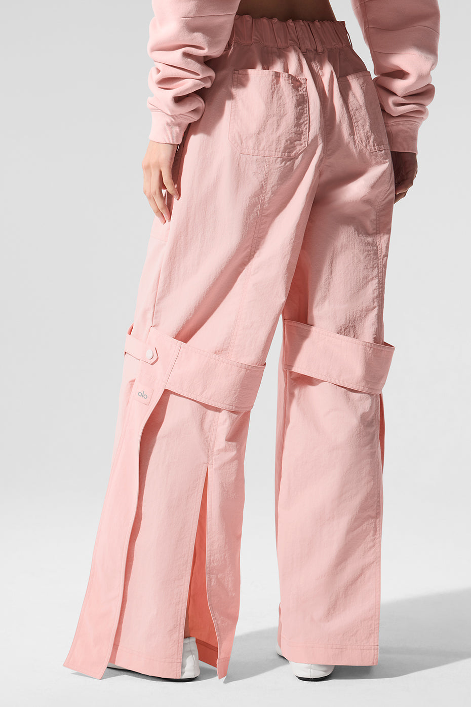 Model showcasing relaxed fit and bottom slits of high-waisted trousers in Pink Quartz