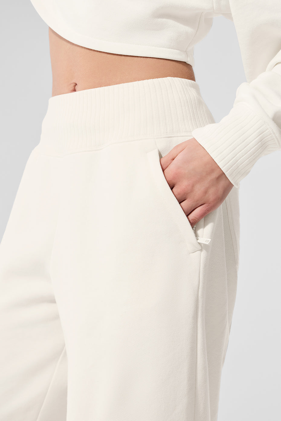 Side profile showing ribbed waistband and zippered pocket details on womens sweatpants