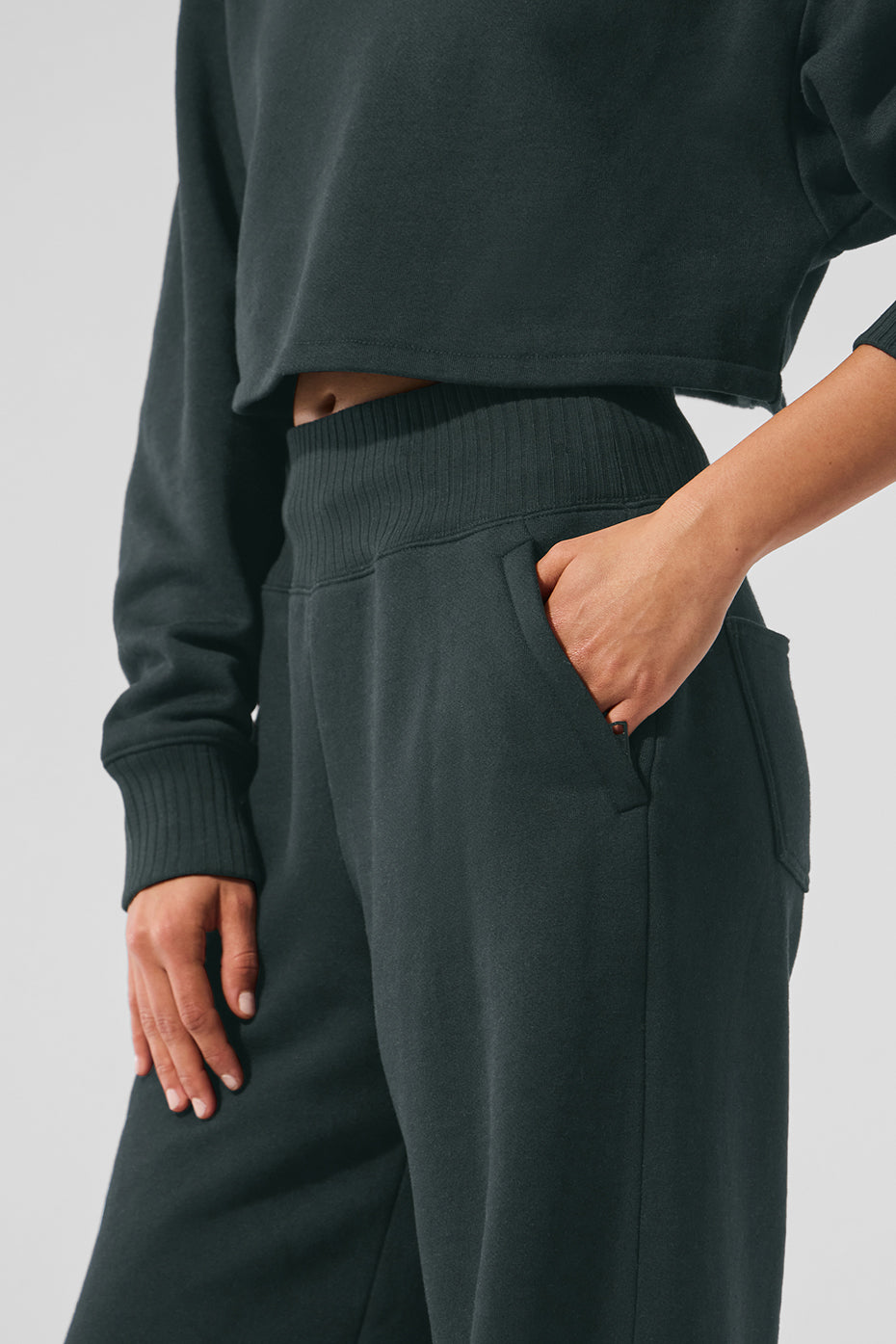 Front view of womens wide leg sweatpants in charcoal green with zippered pockets