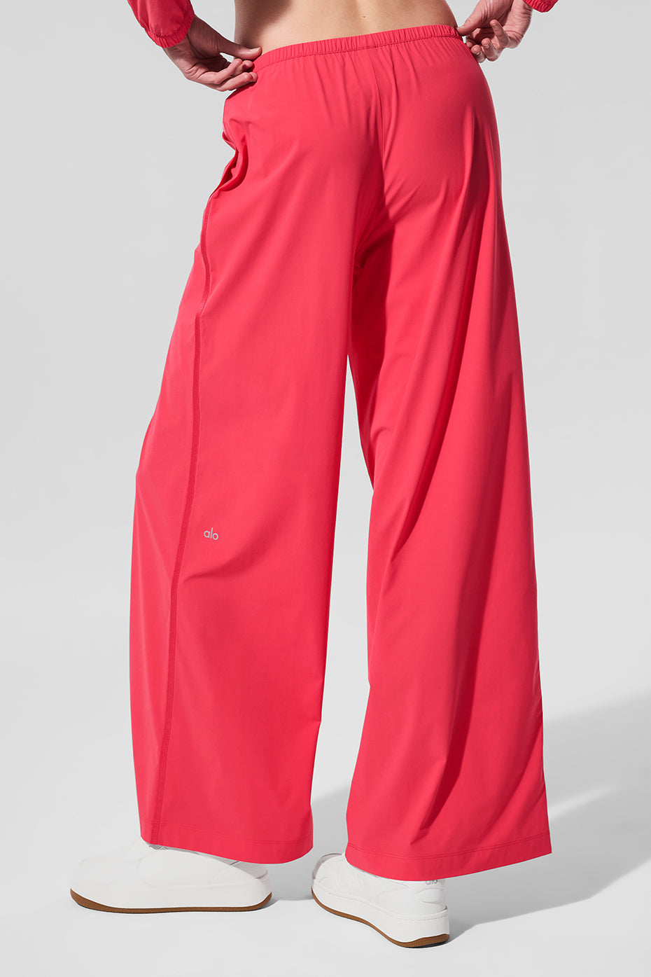 Model showcasing candy red wide leg pants in a stylish setting.