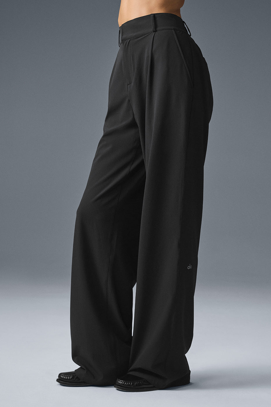Front view of mens trousers pleated with high-waist cut and tapered leg.