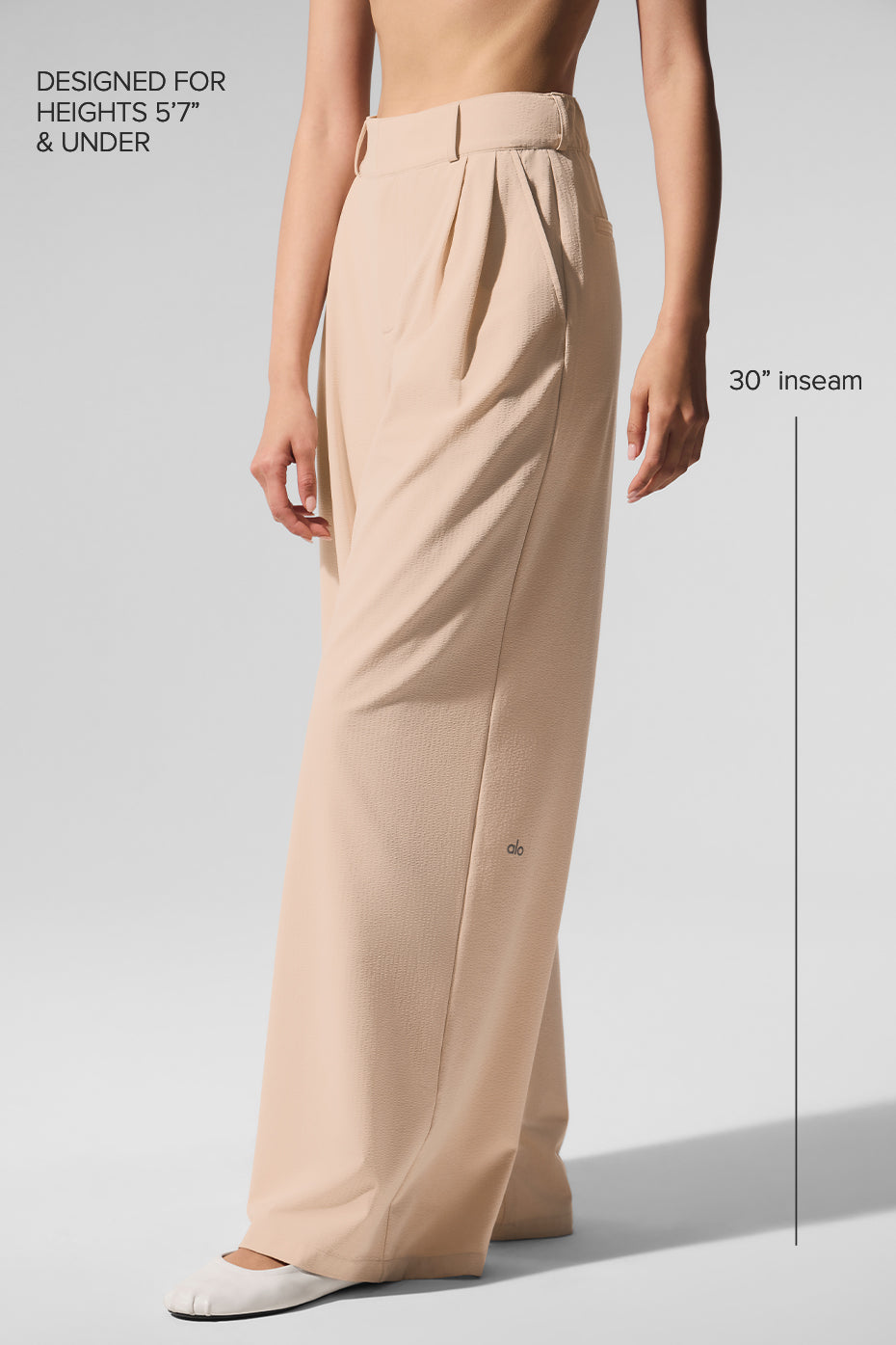 Model pairing pleated trousers pants with a blazer for a smart-casual look