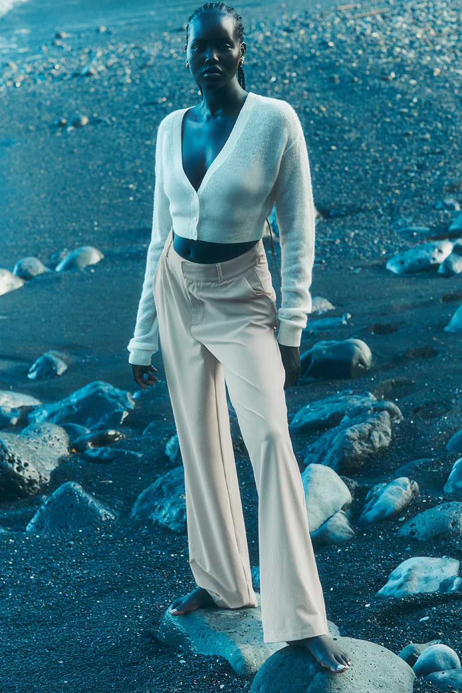 Close-up of high-waist pleated trousers showing the lightweight fabric and pleats