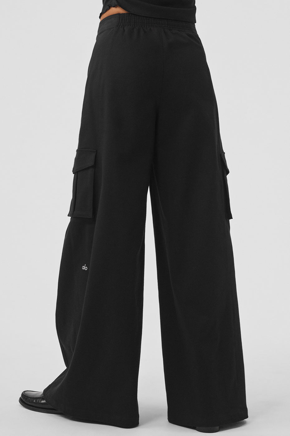 Back view of stylish black wide leg trousers on model.