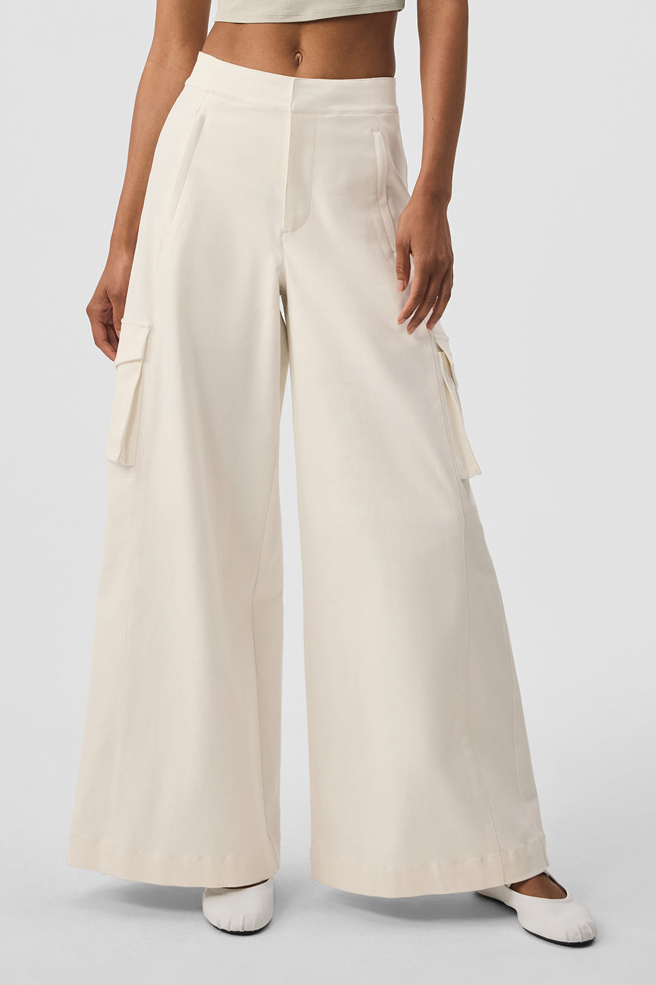 Front view of ivory wide leg trousers with cargo pockets on model
