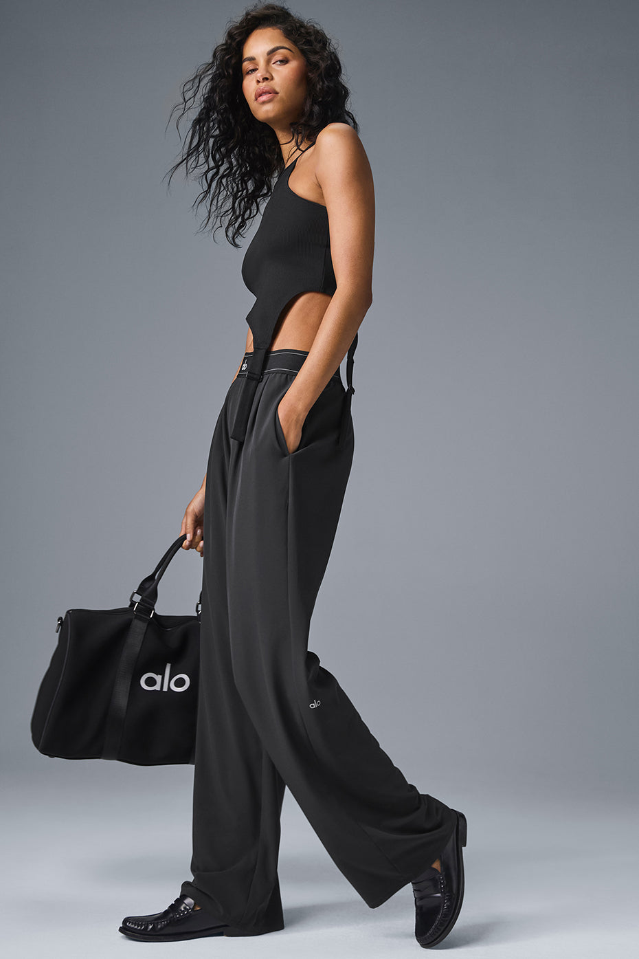 Casual outfit pairing wide-leg black trousers with sneakers