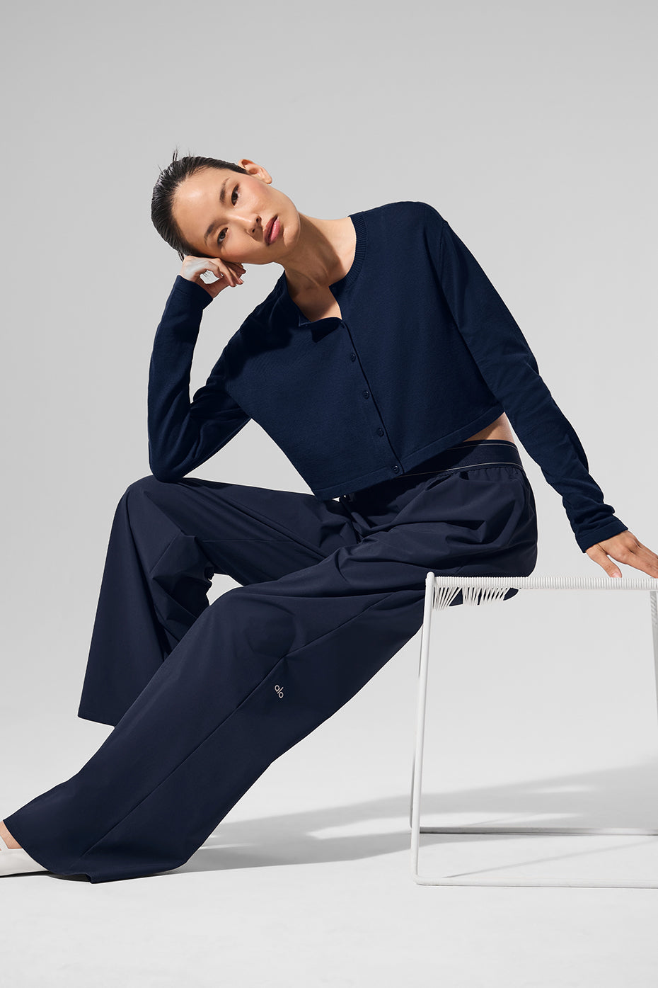Side view of navy trousers displaying loose, straight-leg fit.